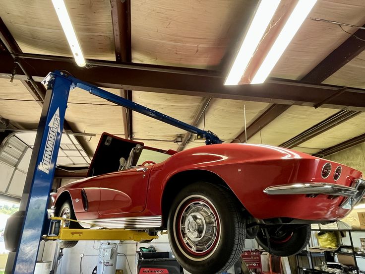 Red Corvette on lift inside Triple H Transmission Hwy 51
